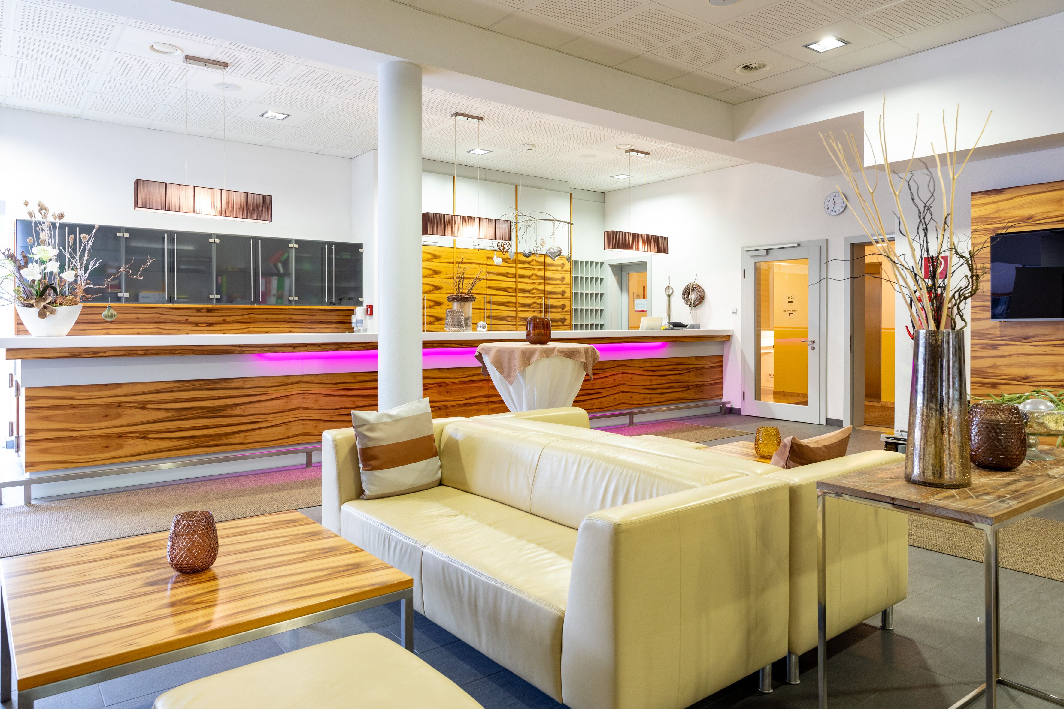 A modern lobby with a reception desk, a sofa, and a coffee table.