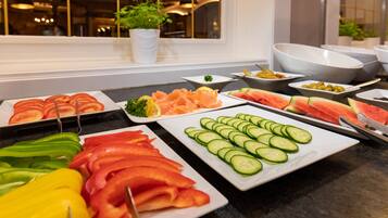 Un buffet proposant une variété de légumes et de fruits coupés en tranches.
