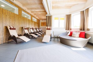 Una piscina techada, sillones reclinables de piscina