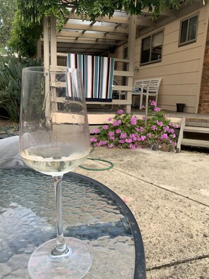 Enjoy a glass of wine on the patio, surrounded by a charming garden and comfortable seating.