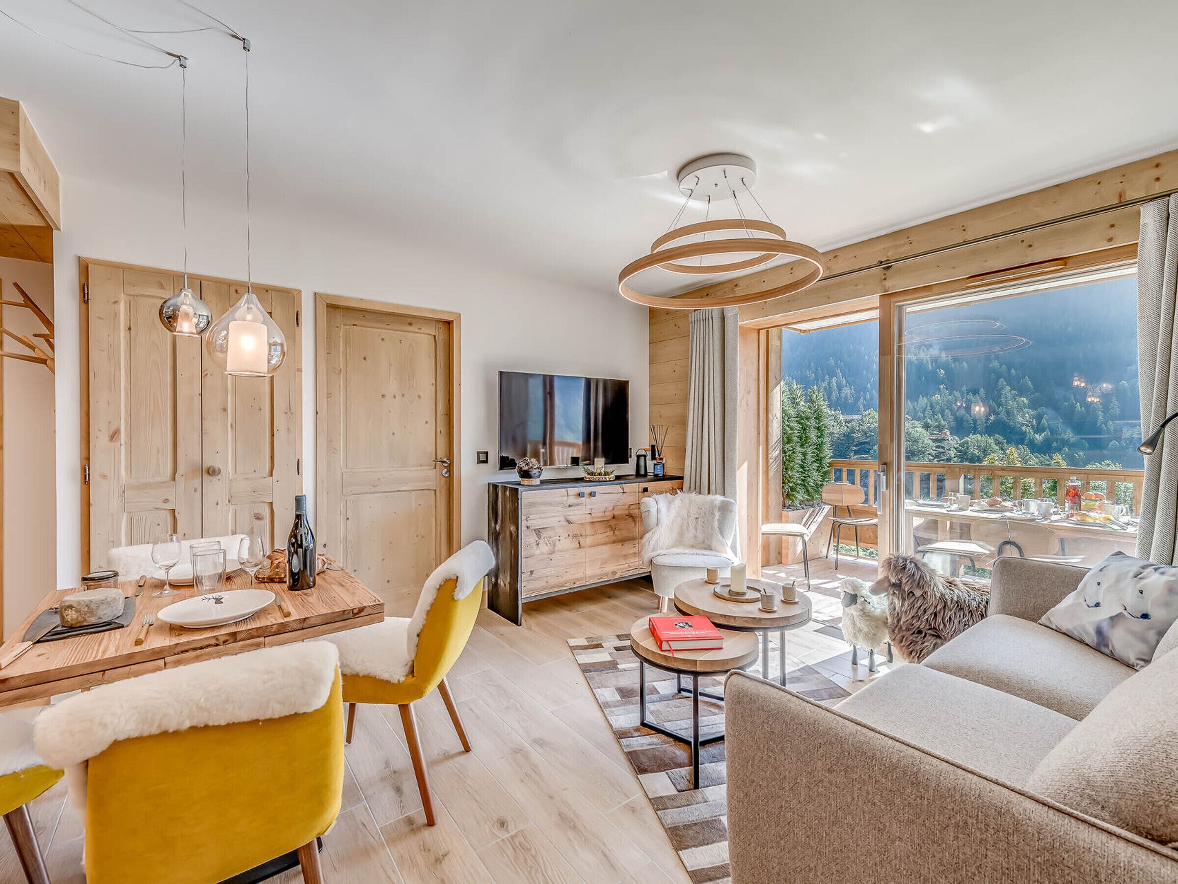 Ein modernes Wohnzimmer mit großem Fenster, Essbereich und gemütlicher Sitzecke.