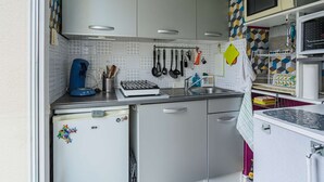 Une cuisine compacte équipée d’un réfrigérateur, d’un four à micro-ondes et d’une machine à café.