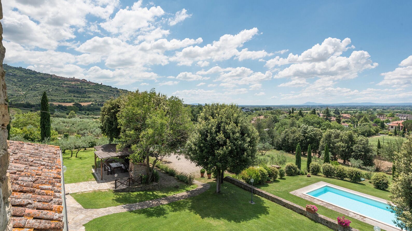 Una villa con piscina, patio e vista sulla campagna.