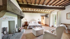 A bedroom with a bed, a chair, a nightstand, and a window. - Elks Tower (Toscana)