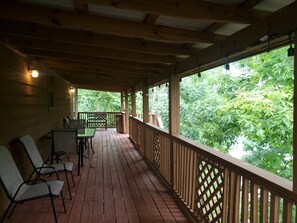 A wooden deck with a view of lush greenery.
