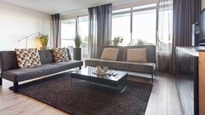 Un salon moderne avec un canapé, une table basse et un téléviseur.