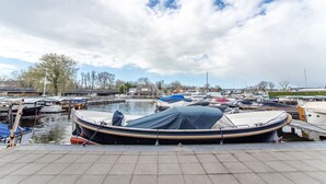 Un puerto deportivo con varias embarcaciones amarradas, una masa de agua tranquila y un cielo despejado.