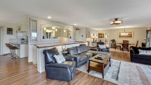 A modern living room with a sofa, coffee table, and dining area. - Beautiful views of Little Traverse Bay and a spacious wraparound deck (Petoskey)
