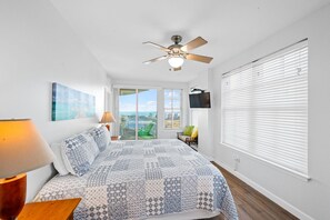 A bedroom with a bed, a ceiling fan, a TV, and a balcony with a view. - Indies 510 | 3BR/3BA Beachfront Condo | Sleeps 6 | Gulf Views (Gulf Shores)