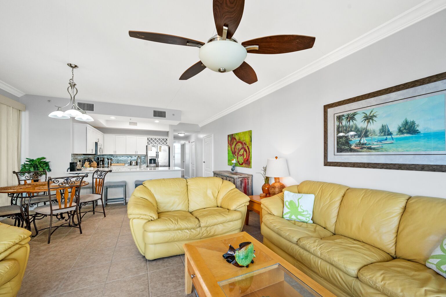 A modern living room with a yellow leather sofa, a wooden coffee table, and a ceiling fan.