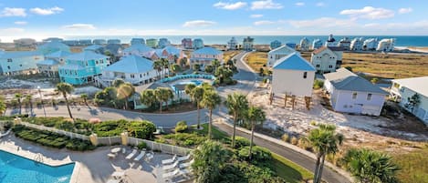 Un resort con piscina, villas frente a la playa y vista despejada al océano.