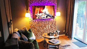 Ein gemütliches Wohnzimmer mit Kamin, einer Couch und einem Couchtisch.