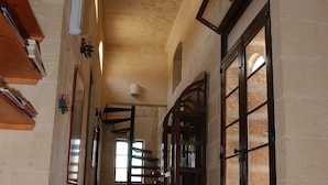 A hallway with a tiled floor, wooden doors, and a staircase leading to another level. - Gozo Holiday Farmhouse Accommodation (Gharb Gozo)
