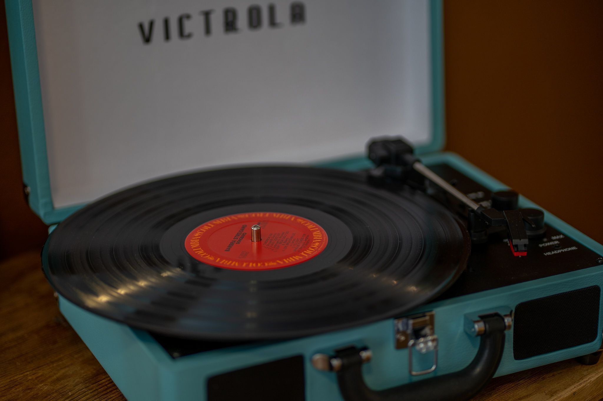 Un tocadiscos color turquesa con un disco de vinilo.