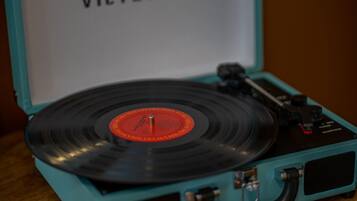 Un tocadiscos color turquesa con un disco de vinilo.