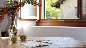 A wooden desk with a vase of red berries, a notebook, and a pen. - 2 1/2-room vacation apartment in Vercana, quiet and inviting above Lake Como (Vercana)