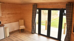 A wooden-paneled room with a sliding glass door leading to an outdoor area.