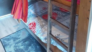 A bunk bed with a ladder, a wall-mounted light, and a patterned bedspread. - Studio cabin Piau Engaly, at the foot of the slopes (Piau-Engaly)