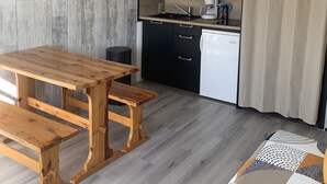 A compact kitchen with a wooden table and benches, a microwave, and a coffee maker. - Studio cabin Piau Engaly, at the foot of the slopes (Piau-Engaly)