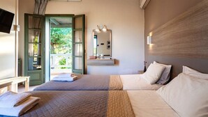 Une chambre d’hôtel avec deux lits, un miroir, une télévision et une vue sur l’extérieur.