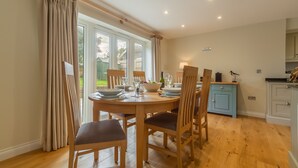 A dining area with a round wooden table set for four, surrounded by chairs. - The Sidings, Docking, Norfolk (Docking)