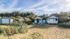 A beachside property with three cabins, each with a porch and seating area. - The Big Barn, Snettisham, Norfolk (Snettisham)