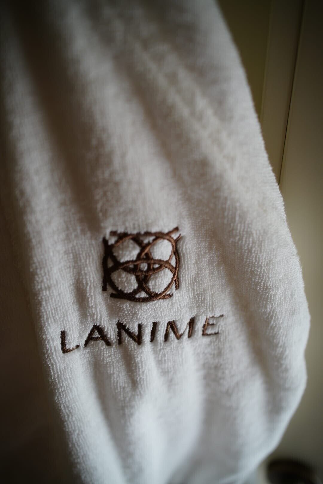 Een witte handdoek met geborduurd tekst en een logo.
