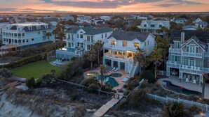 A coastal residential area with multiple houses featuring balconies, a swimming pool, and a beach access area. - 🌅Coastal Sunrise🌅Ocean Front on Ocean Blvd. Private Pool/hot tub, stunning ocean views! (Isle Of Palms)
