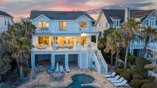 A large two-story house with a swimming pool, outdoor seating, and a staircase leading to a balcony. - 🌅Coastal Sunrise🌅Ocean Front on Ocean Blvd. Private Pool/hot tub, stunning ocean views! (Isle Of Palms)