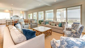 A spacious living area with a sofa, armchairs, a coffee table, and a balcony with a view. - 🌅Coastal Sunrise🌅Ocean Front on Ocean Blvd. Private Pool/hot tub, stunning ocean views! (Isle Of Palms)