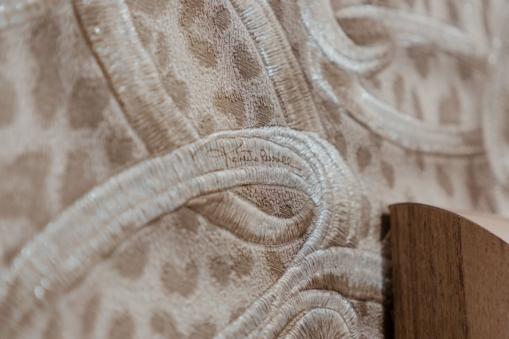 A close-up of a fabric with a textured pattern and a wooden object.