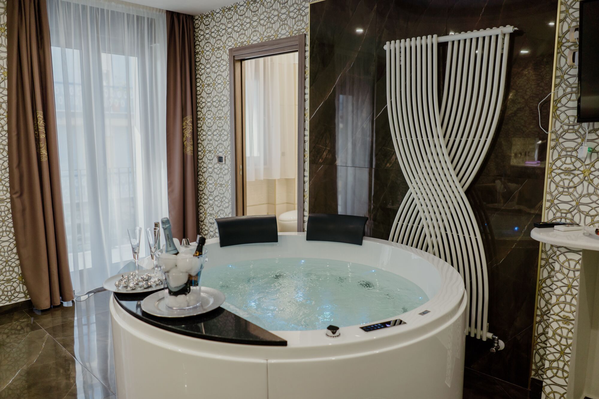 Un baño moderno con una bañera grande, una cortina de ducha y un lavamanos con espejo.