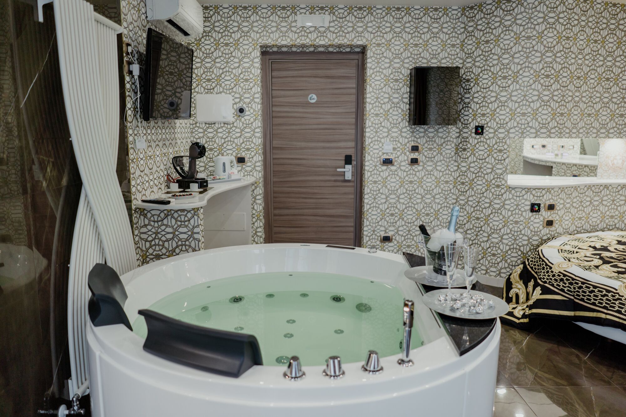 Un baño con una bañera grande, ducha, inodoro y lavamanos. Hay un perchero y un espejo sobre el lavamanos.