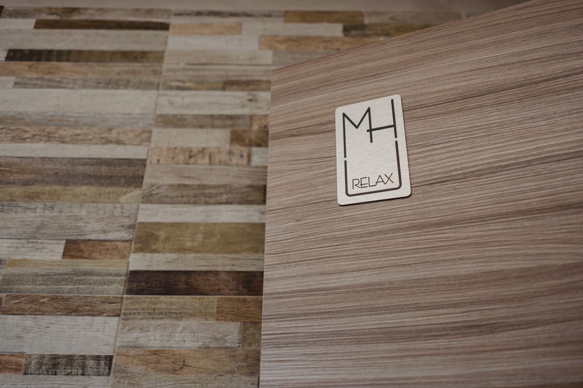 Ein Holzboden mit einem Schild, auf dem 'MH RELAX' steht.