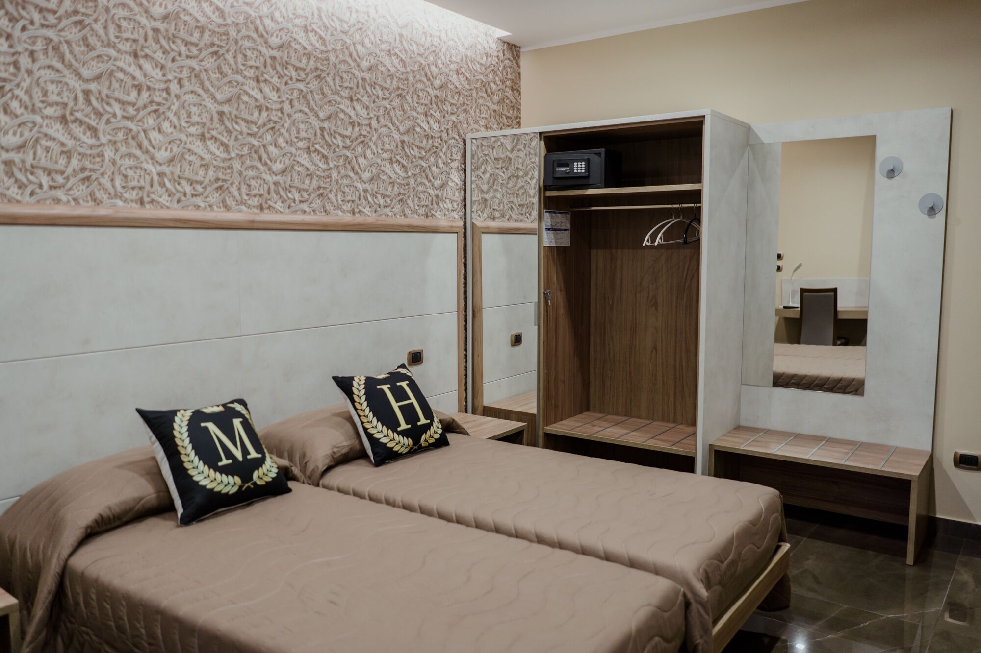 Un dormitorio con dos camas, un armario y un espejo.