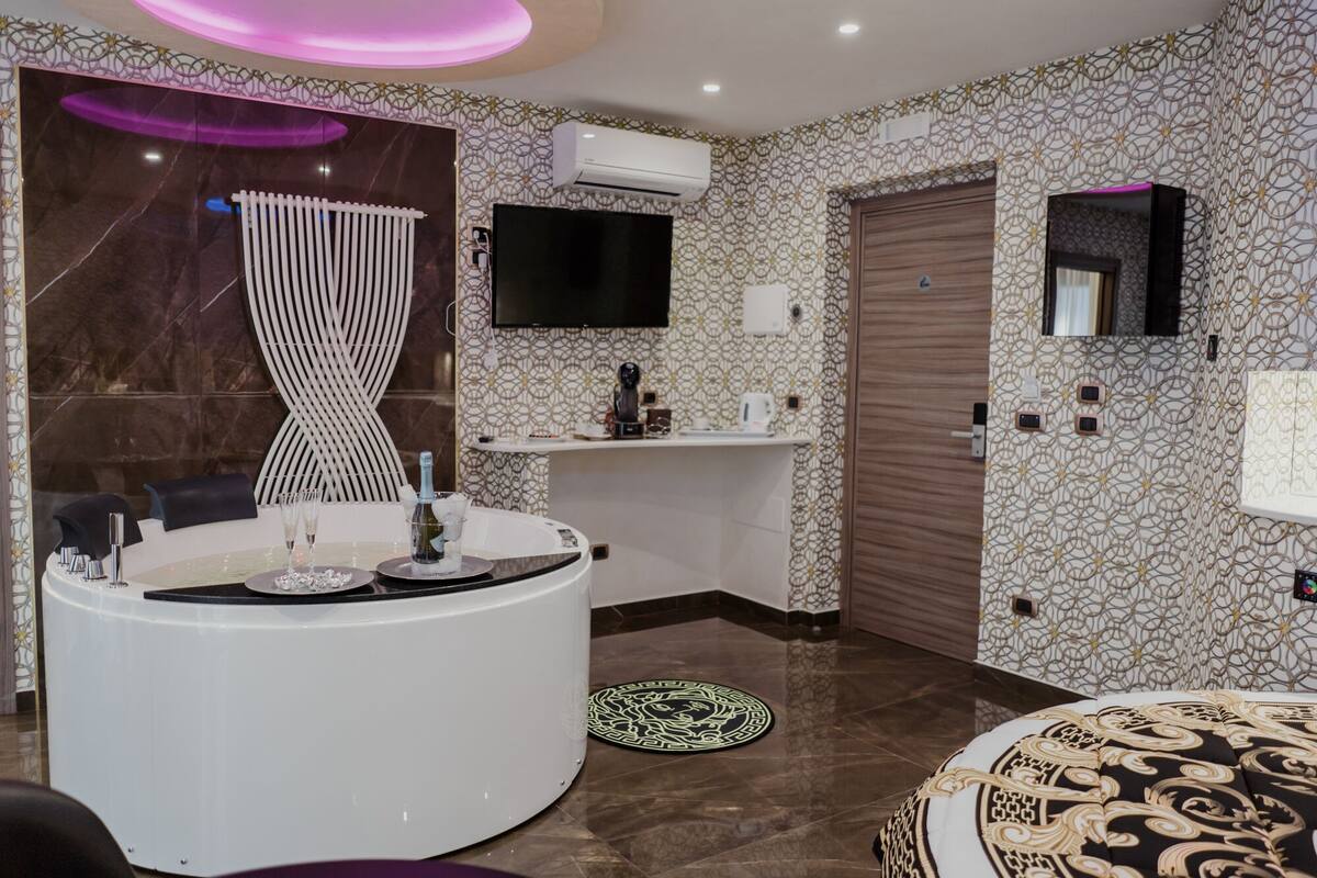 A modern bathroom with a curved vanity, a large mirror, and a shower area.