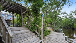Una escalera de madera que conduce a una zona cubierta con vistas al río.