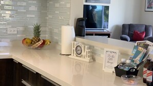 A modern kitchen with a white countertop, a fruit bowl, a coffee maker, and a sign that reads "It's the little things." - Beautiful Full House Rental in Private Gated Community,  Montego Bay, Jamaica (Montego Bay)