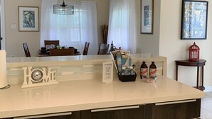 A modern kitchen with a central island, dark wood cabinets, and a white countertop. - Beautiful Full House Rental in Private Gated Community,  Montego Bay, Jamaica (Montego Bay)