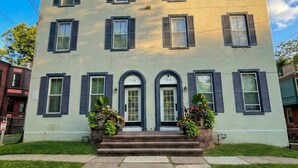 A two-story building with a symmetrical facade, featuring a central entrance with double doors and a small porch area. - The Grayson at Park Place - Historic Charm Meets Modern Comfort (Wilmington)