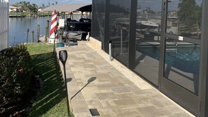Un espacio al aire libre cubierto con piscina, césped y vistas a un lago.