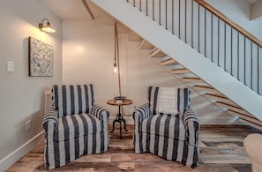 Una escalera de madera con barandales de metal que sube a un piso superior.