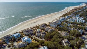 Zona residencial costera con casas a lo largo de la playa y una vista despejada del océano.