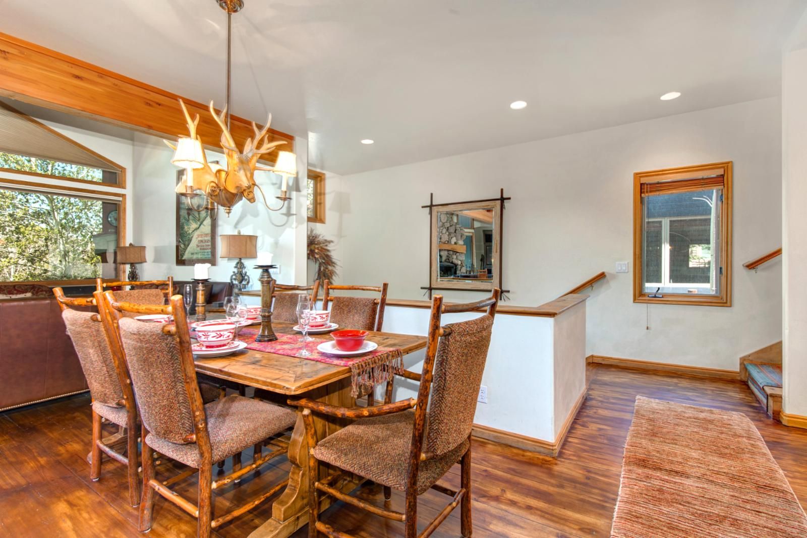 A dining area with a wooden table, chairs, and a chandelier.