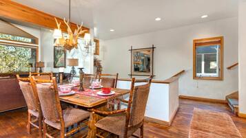 A dining area with a wooden table, chairs, and a chandelier.