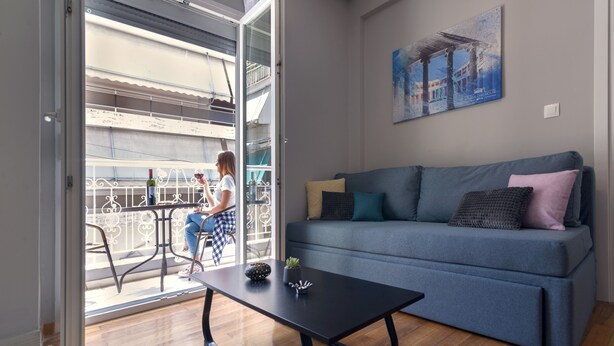 A living room with a sofa, a coffee table, and a balcony with a railing. - Athens Chic House Apt B2 42sq.m 1st Floor (Athina)