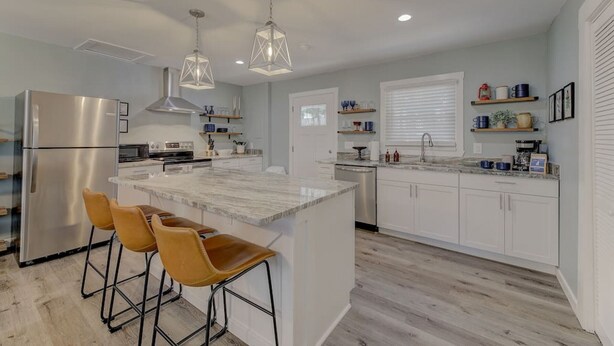 A modern kitchen with a large island, stainless steel appliances, and pendant lighting. - Fort Jackson Family Abode 3BD 2BA Home RENOVATED (Columbia)