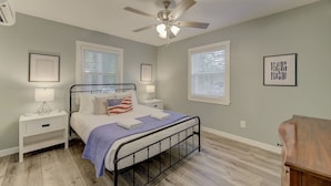 A bedroom with a bed, two bedside tables, a ceiling fan, and a window with blinds. - Fort Jackson Family Abode 3BD 2BA Home RENOVATED (Columbia)