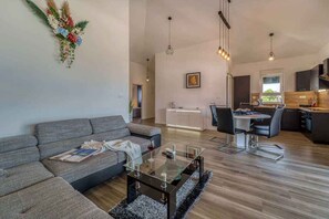 Un salon moderne avec un canapé, une table basse et un coin repas.