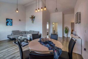 Una sala moderna con un sofá, una mesa de centro y un comedor con sillas.